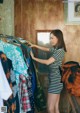 A woman standing in front of a rack of clothes.