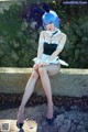 A woman in a bunny costume sitting on a stone wall.