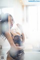 A woman in a black lingerie leaning against a wall.