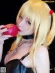 A woman with long blonde hair holding an apple in her hand.