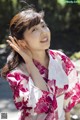 A woman in a pink and white kimono posing for a picture.