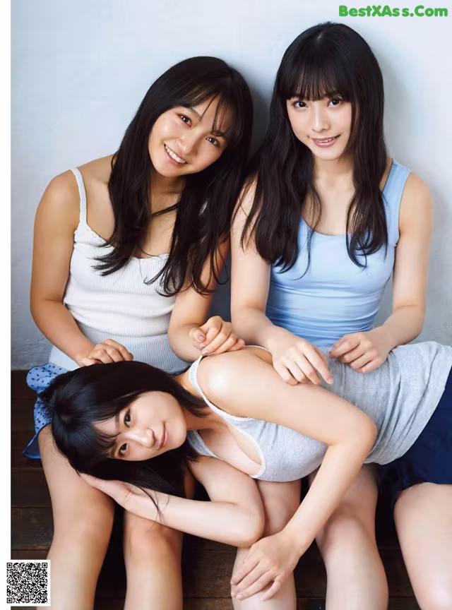 A group of three young women sitting next to each other.