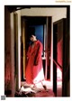 A woman in a red coat standing in a doorway.