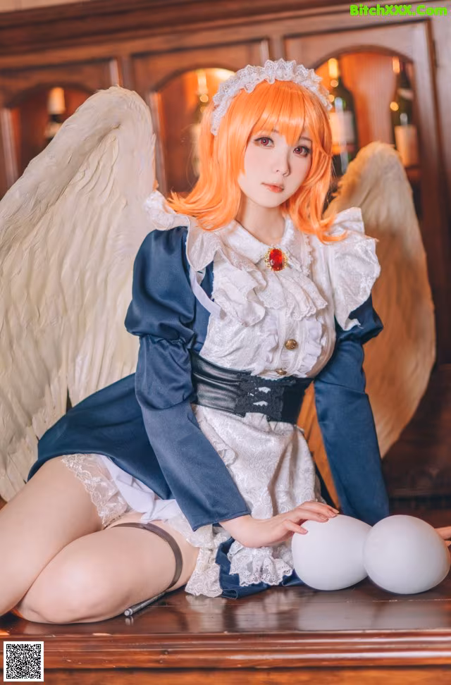 A woman dressed as an angel sitting on top of a table.