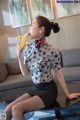 A woman sitting on a table eating a banana.